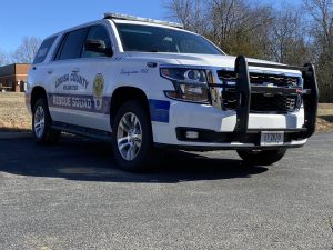 A louisa county volunteer rescue squad suv parked outdoors on a sunny day, featuring a white and blue color scheme with emergency lights and a push bumper.